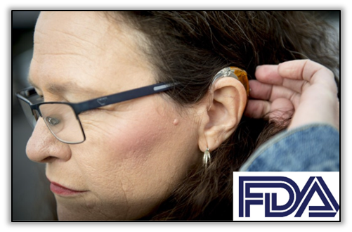 middle-aged woman with glasses touching her hearing aid. FDA logo in bottom right hand corner